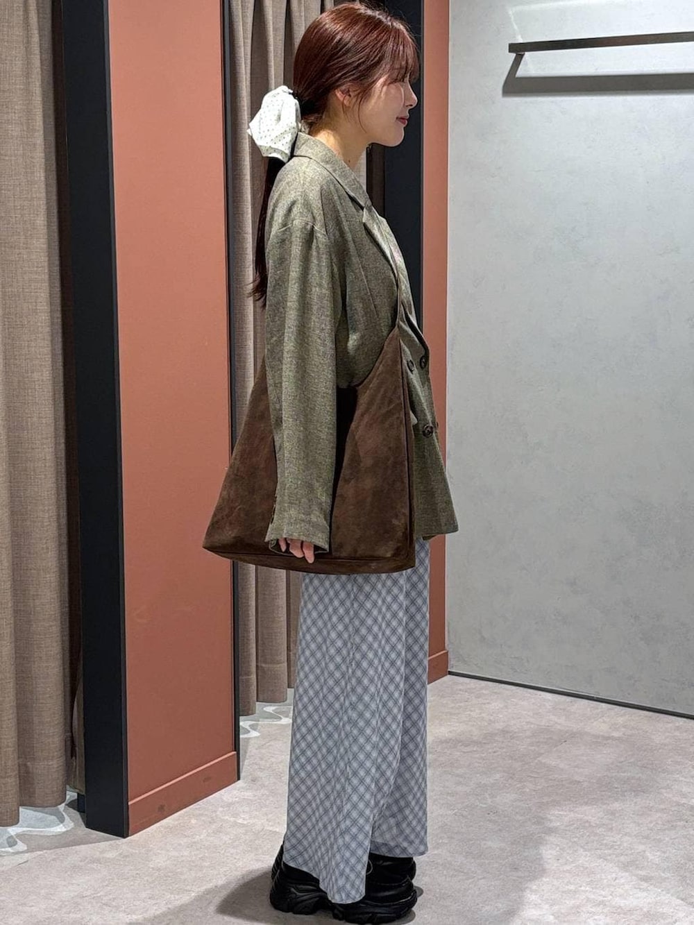 ブラウン系のショルダーバッグ、ブラウン系のテーラードジャケット、ブラック系のローファーを着用したレディースの春コーディネートの2枚目の写真