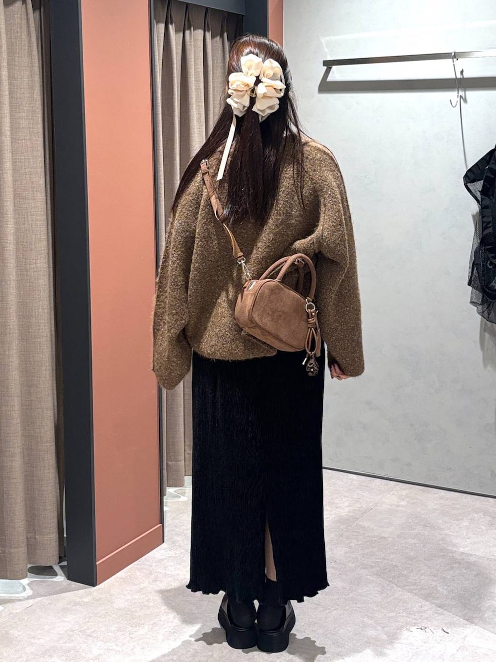 ブラック系のサンダル、ブラック系のスカート、ブラウン系のブルゾンを着用したレディースの秋コーディネートの3枚目の写真