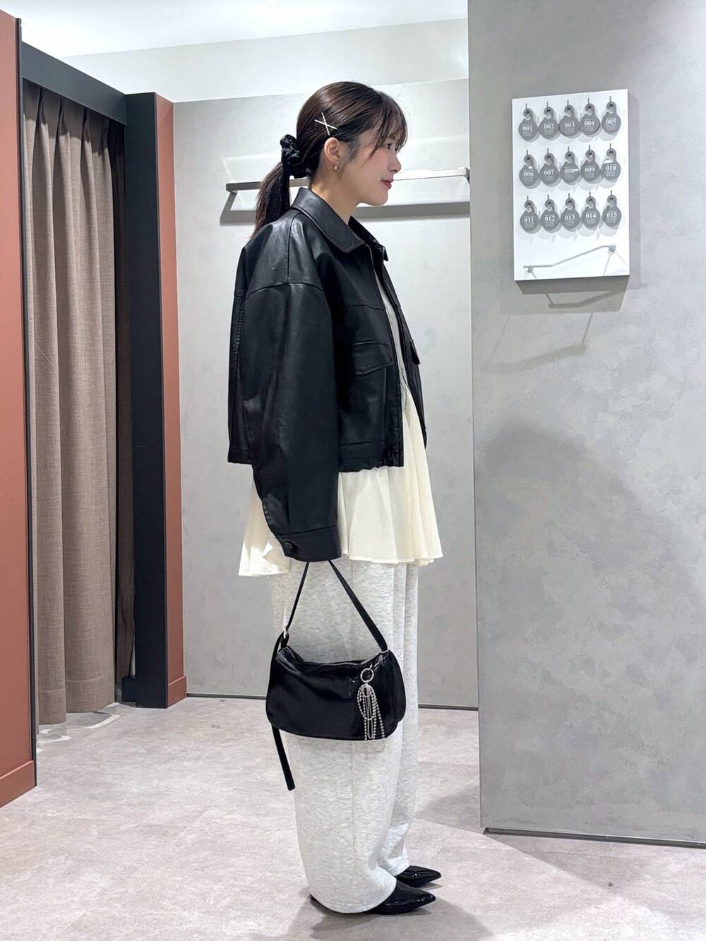 ホワイト系のシャツ/ブラウス、グレー系のカーディガン/ボレロ、ブラック系のトートバッグを着用したレディースの春コーディネートの2枚目の写真