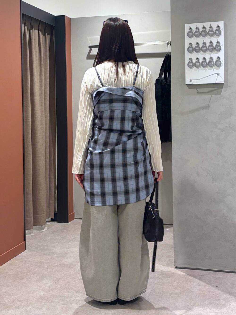 グレー系のデニムパンツ、ブラック系のバレエシューズ、ブラック系のトートバッグを着用したレディースの春コーディネートの3枚目の写真