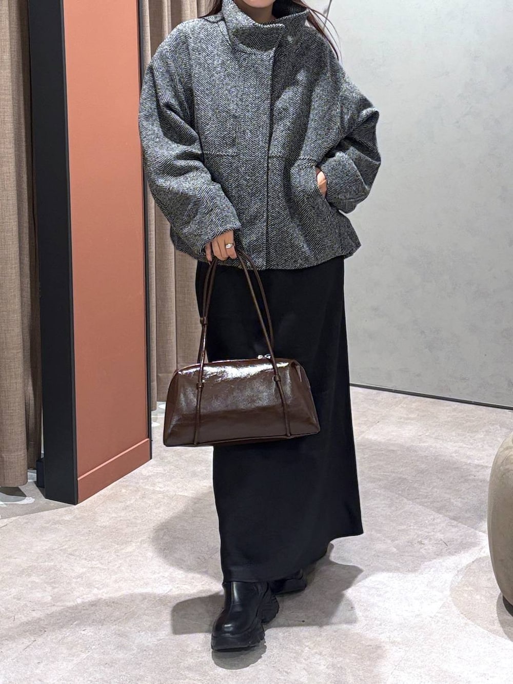 ブラック系のブーツ、ブラック系のスカート、グレー系のブルゾンを着用したレディースの秋コーディネートの4枚目の写真