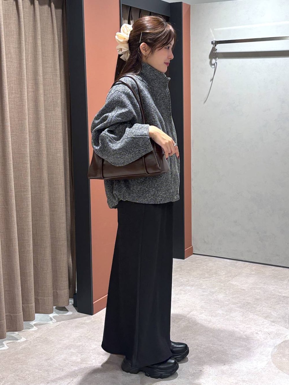 ブラック系のブーツ、ブラック系のスカート、グレー系のブルゾンを着用したレディースの秋コーディネートの2枚目の写真