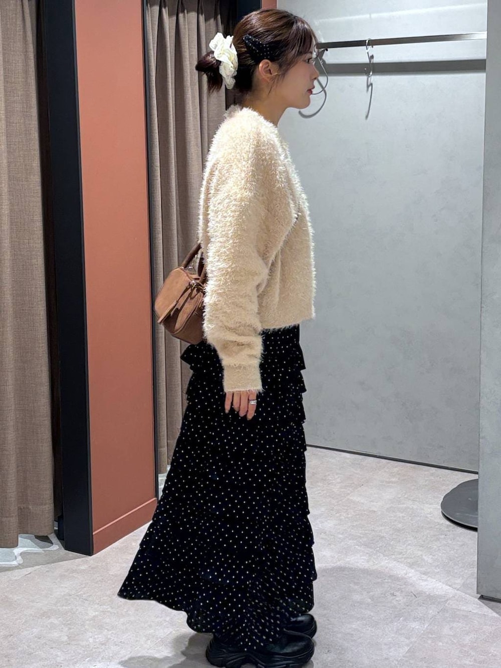 ブラック系のブーツ、その他のスカート、ブラウン系のボストンバッグを着用したレディースの秋コーディネートの2枚目の写真