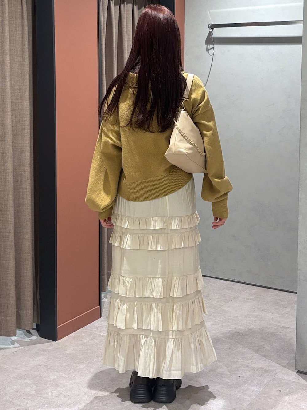 ベージュ系のショルダーバッグ、ブラック系のローファー、ホワイト系のスカートを着用したレディースの冬コーディネートの4枚目の写真