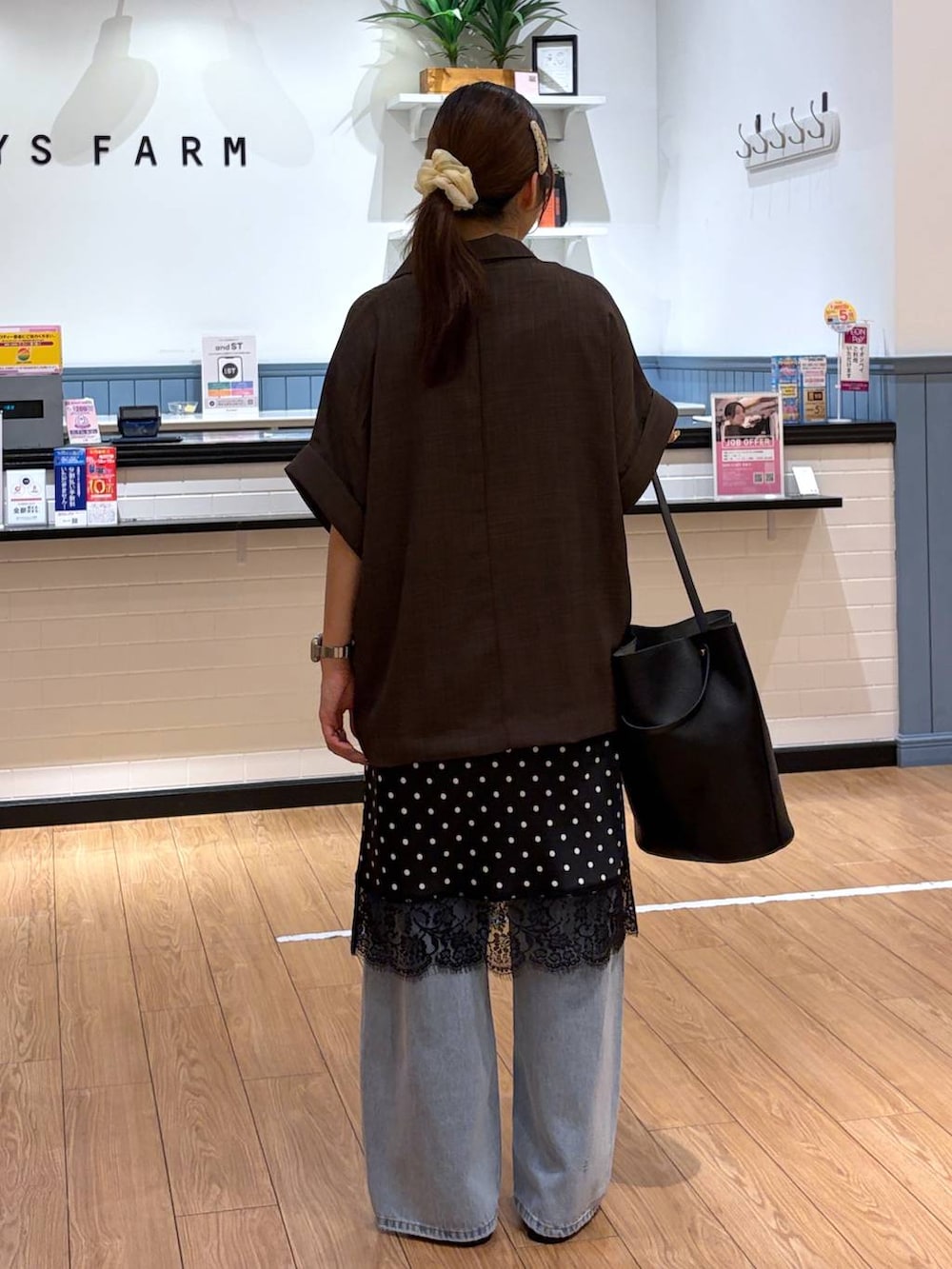 ブルー系のデニムパンツ、ブラウン系のテーラードジャケット、ブラック系のサンダルを着用したレディースの夏コーディネートの3枚目の写真
