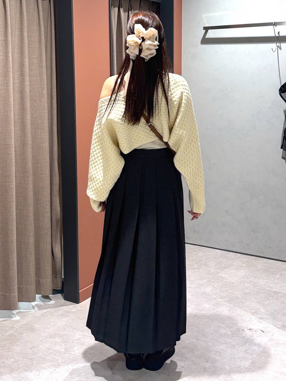 グレー系のスカート、ブラック系のサンダル、ホワイト系のキャミソールを着用したレディースの秋コーディネートの4枚目の写真