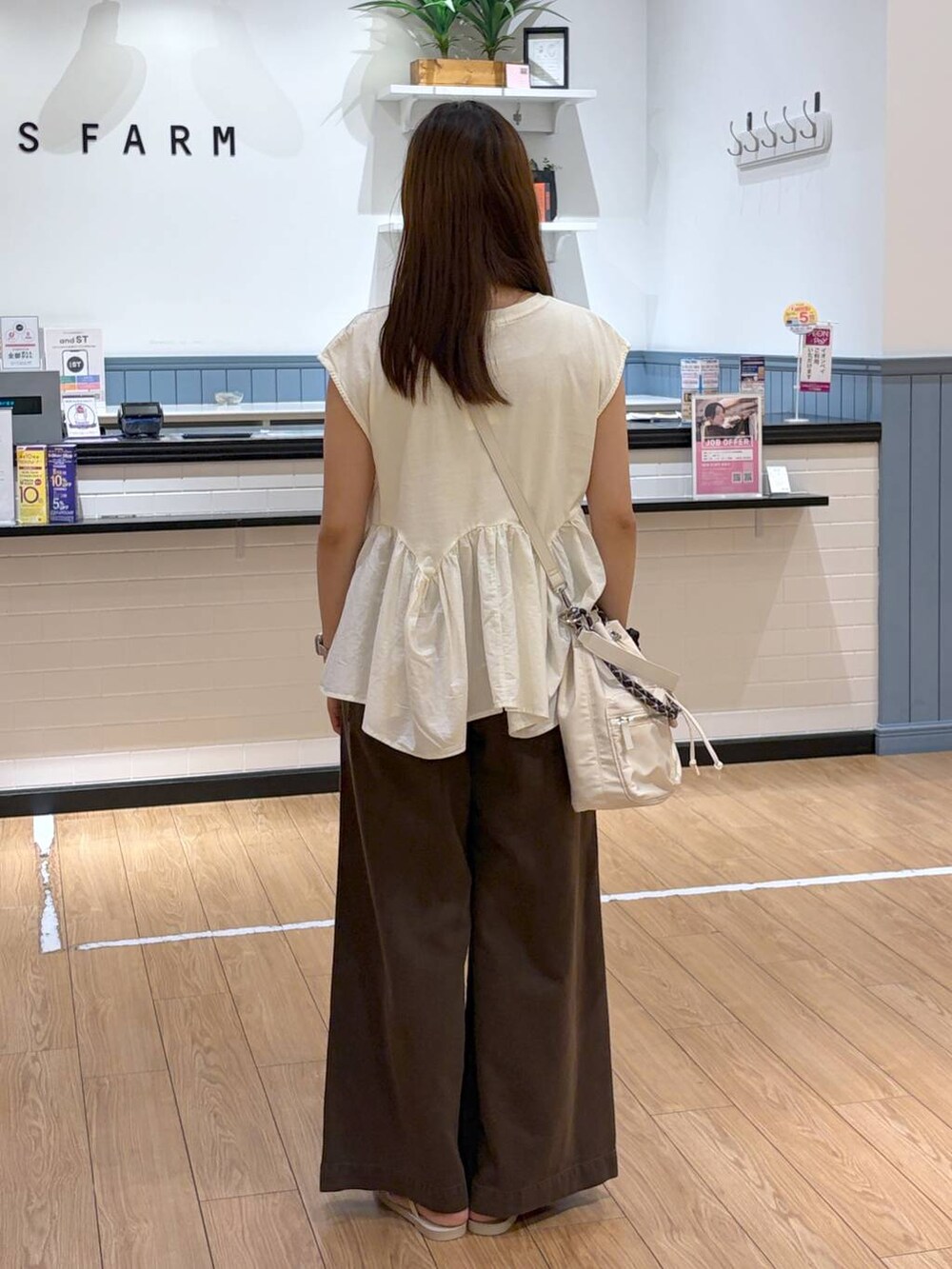 ホワイト系のTシャツ/カットソー、ブラウン系のサンダル、ホワイト系のショルダーバッグを着用したレディースの夏コーディネートの3枚目の写真