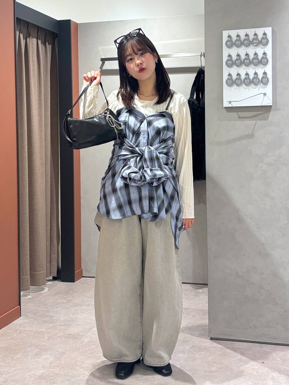 グレー系のデニムパンツ、ブラック系のバレエシューズ、ブラック系のトートバッグを着用したレディースの春コーディネートの4枚目の写真