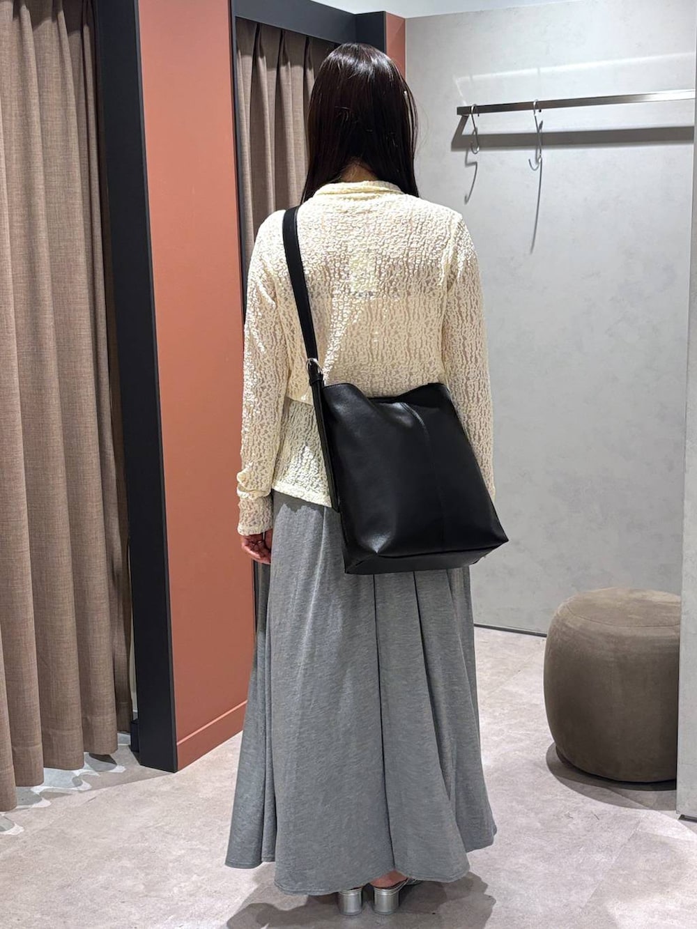 シルバー系のサンダル、グレー系のスカート、ブラック系のショルダーバッグを着用したレディースの夏コーディネートの3枚目の写真