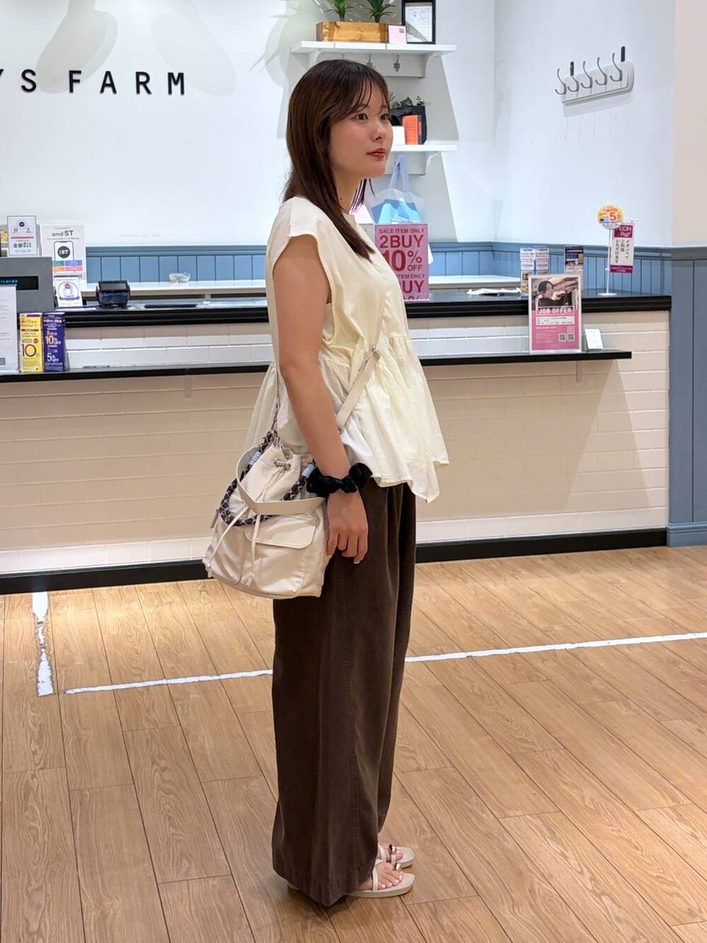 ホワイト系のTシャツ/カットソー、ブラウン系のサンダル、ホワイト系のショルダーバッグを着用したレディースの夏コーディネートの2枚目の写真