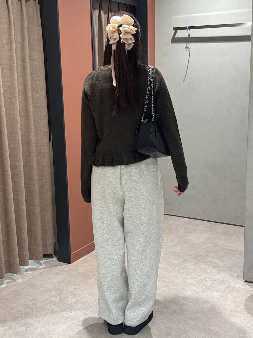 グレー系のスウェットパンツ、ブラック系のその他シューズ、ブラウン系のニット/セーターを着用したレディースの秋コーディネートの3枚目の写真