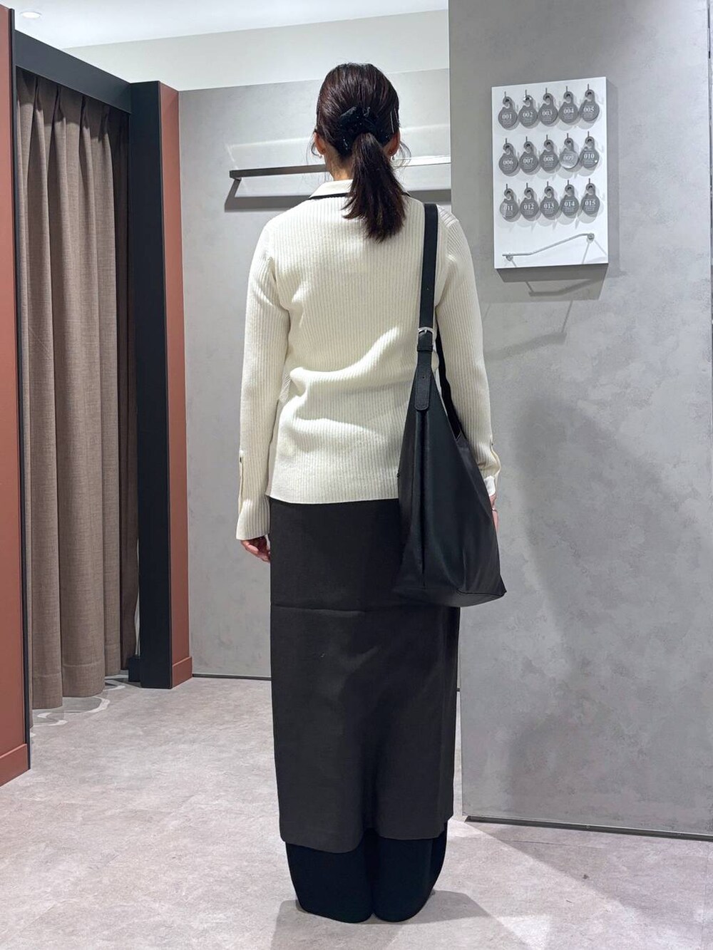 ブラック系のショルダーバッグ、ブラック系のスウェットパンツ、ホワイト系のカーディガン/ボレロを着用したレディースの春コーディネートの3枚目の写真
