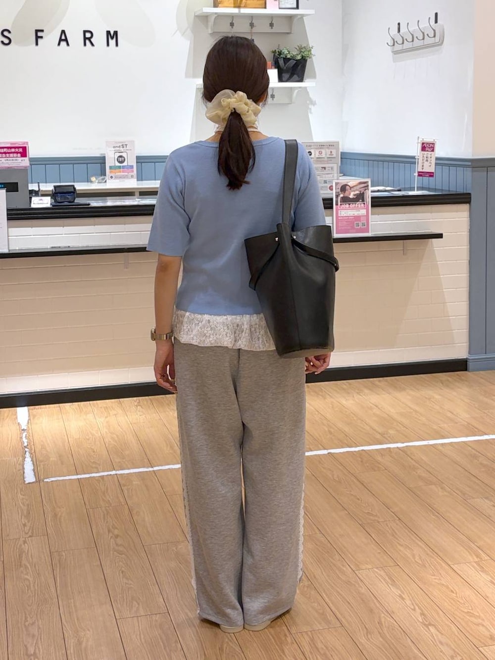 グレー系のスウェットパンツ、ブラック系のショルダーバッグ、ホワイト系のキャミソールを着用したレディースの春コーディネートの5枚目の写真