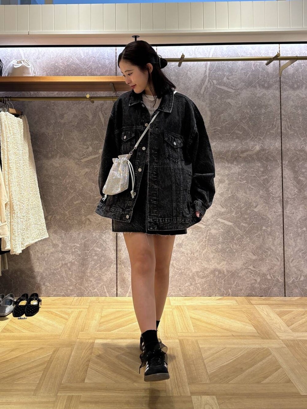 ブラック系のデニムスカート、グレー系のキャミソール、シルバー系のショルダーバッグを着用したレディースの秋コーディネートの2枚目の写真