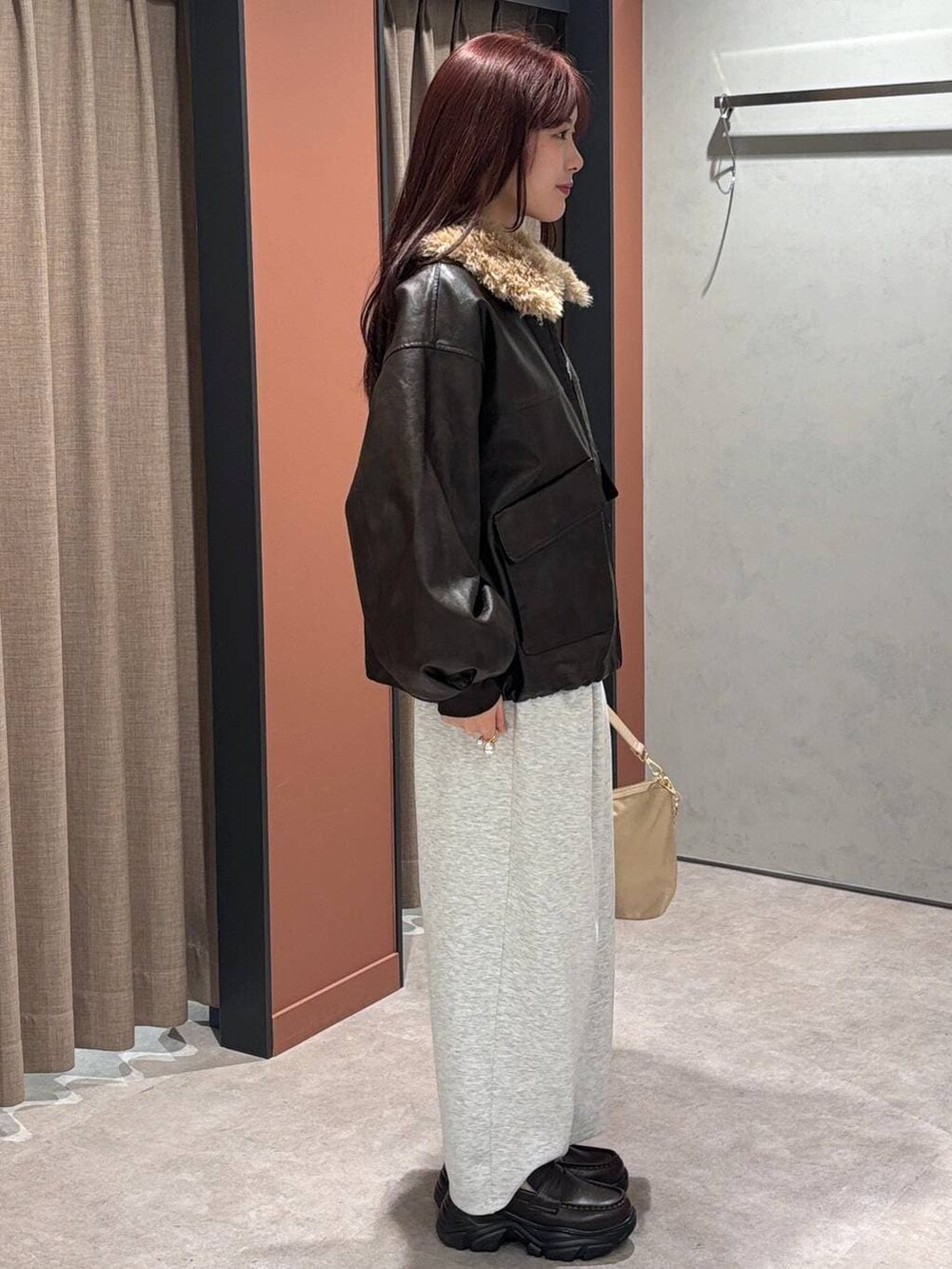 グレー系のスウェットパンツ、ベージュ系のショルダーバッグ、ブラック系のローファーを着用したレディースの冬コーディネートの2枚目の写真