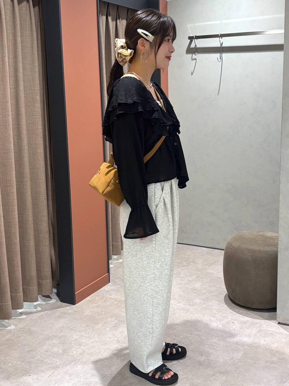 ブラック系のサンダル、グレー系のスウェットパンツ、ブラウン系のショルダーバッグを着用したレディースの夏コーディネートの2枚目の写真