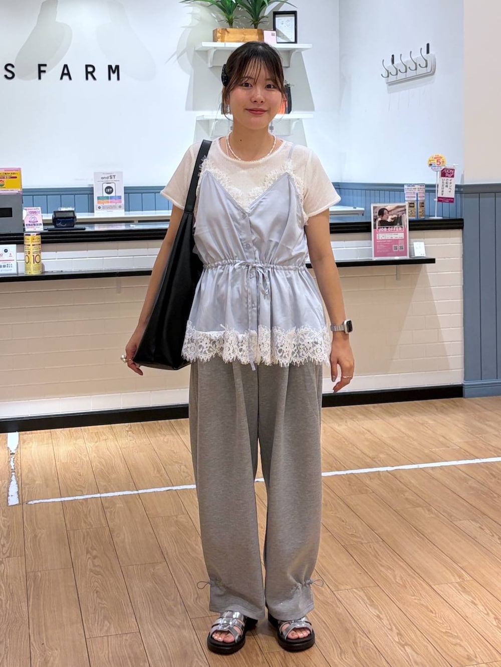 グレー系のスウェットパンツ、ブルー系のキャミソール、ブラック系のショルダーバッグを着用したレディースの夏コーディネートの3枚目の写真