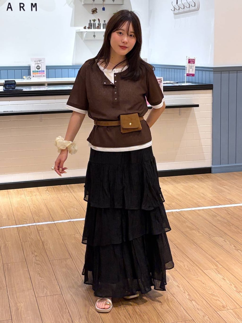 ホワイト系のサンダル、ブラウン系のTシャツ/カットソー、ブラック系のスカートを着用したレディースの春コーディネートの3枚目の写真