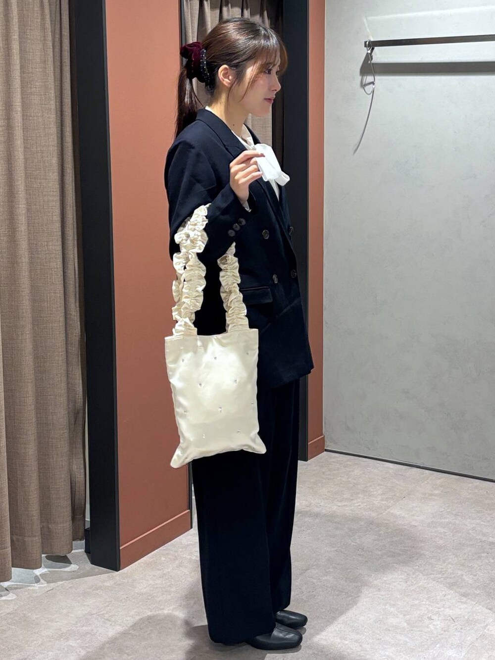 ブラック系のブーツ、ブルー系のテーラードジャケット、ブルー系のスラックスを着用したレディースの冬コーディネートの2枚目の写真