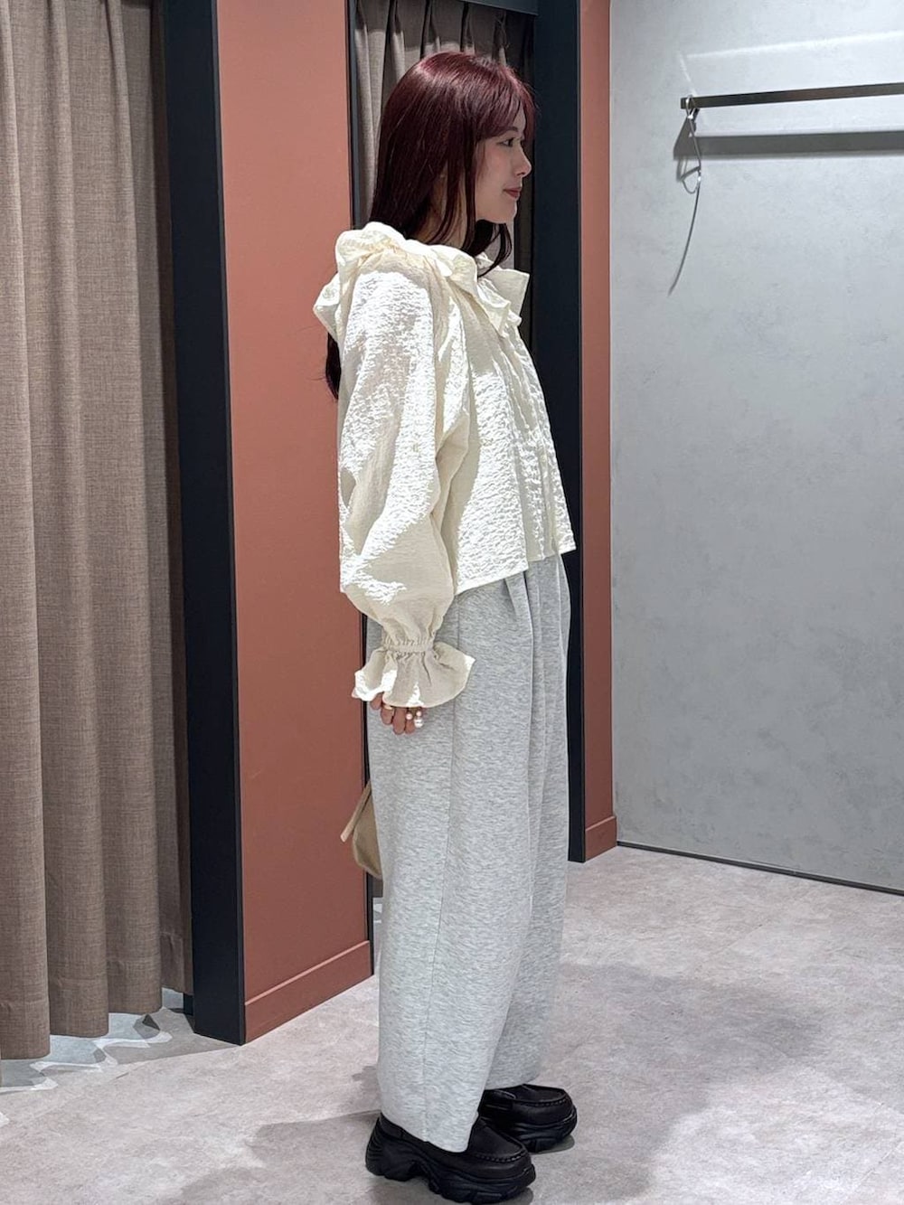 グレー系のスウェットパンツ、ベージュ系のショルダーバッグ、ブラウン系のローファーを着用したレディースの冬コーディネートの3枚目の写真