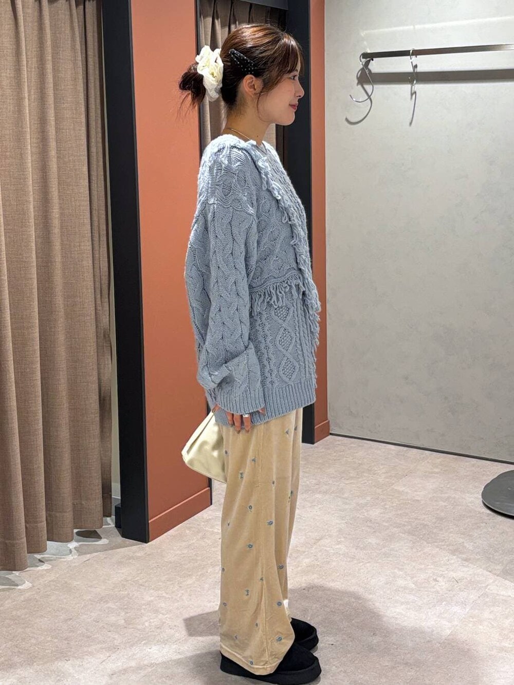 ブラック系のその他シューズ、ブルー系のニット/セーター、ホワイト系のショルダーバッグを着用したレディースの秋コーディネートの2枚目の写真