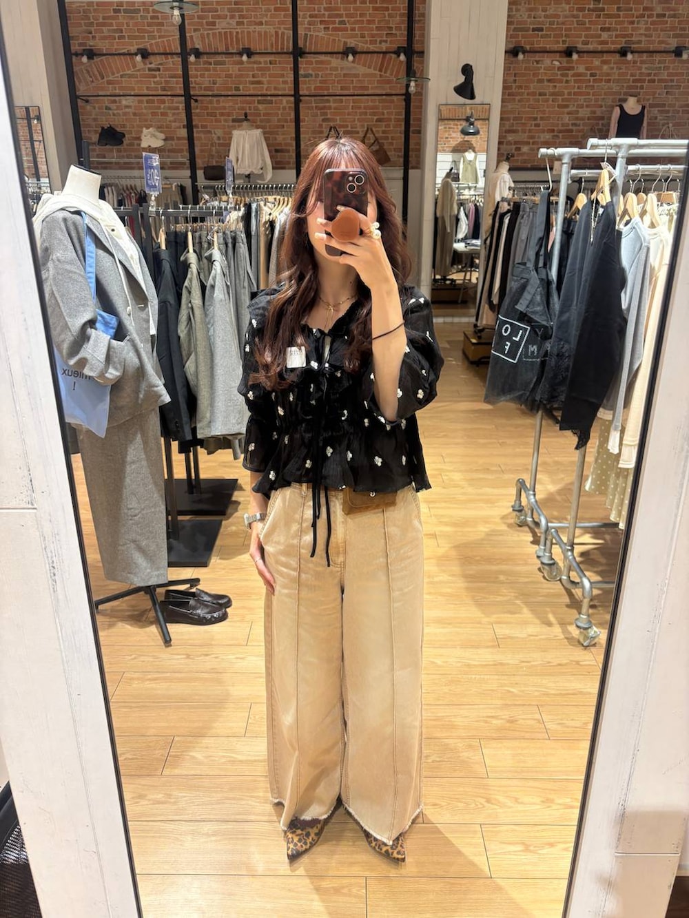 ブラウン系のパンプス、オレンジ系のデニムパンツ、ブラック系のシャツ/ブラウスを着用したレディースの春コーディネートの2枚目の写真