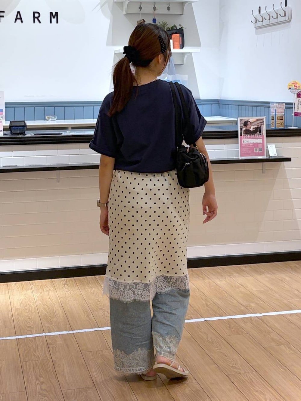 ブルー系のデニムパンツ、ホワイト系のサンダル、ホワイト系のスカートを着用したレディースの夏コーディネートの3枚目の写真