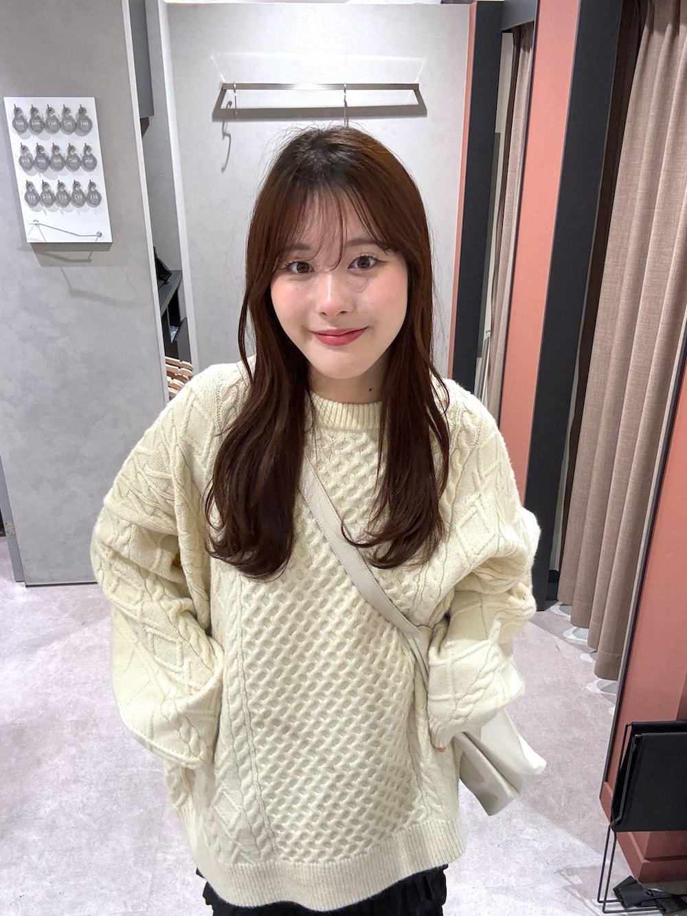 ホワイト系のショルダーバッグ、ホワイト系のニット/セーターを着用したレディースの冬コーディネートの4枚目の写真