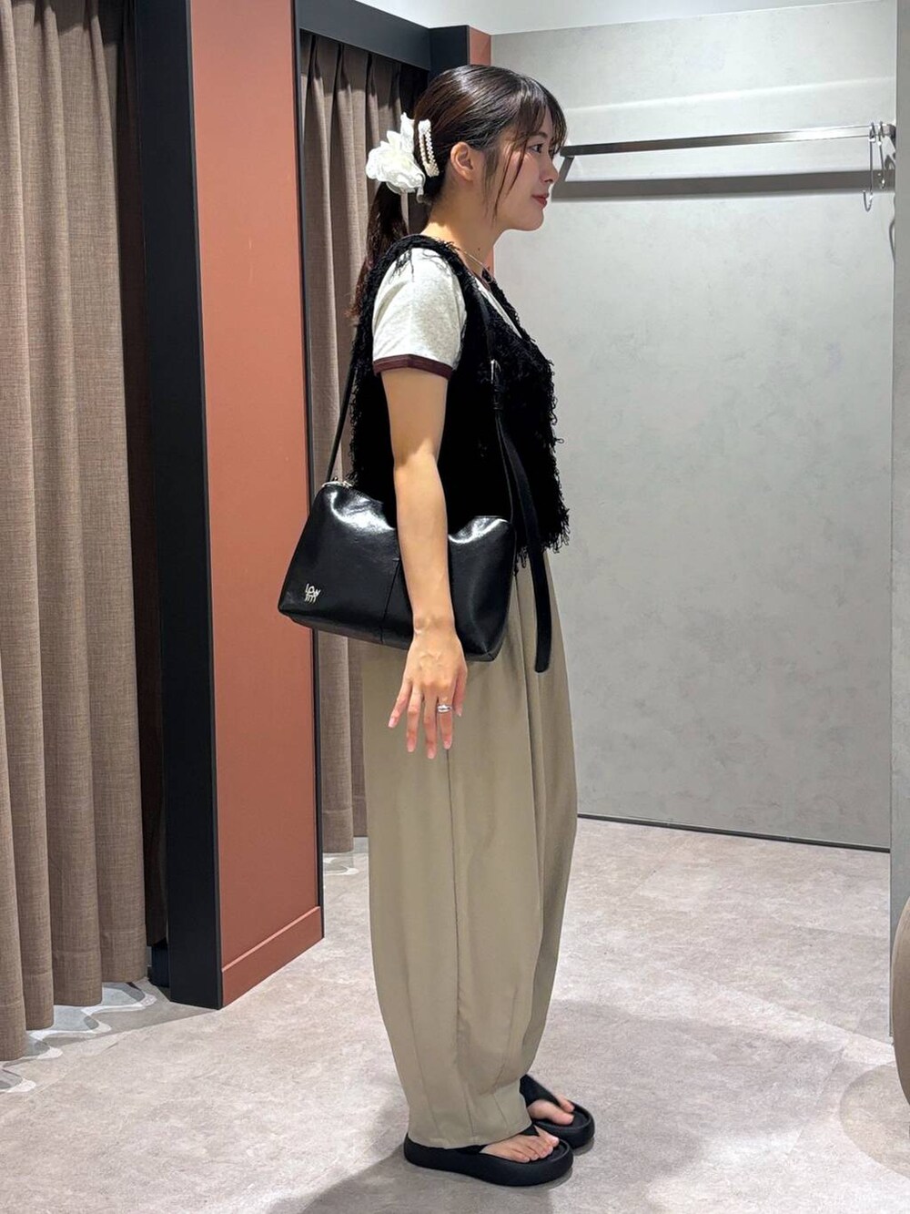 ブラック系のサンダル、ブラック系のショルダーバッグ、ベージュ系のその他パンツを着用したレディースの夏コーディネートの2枚目の写真