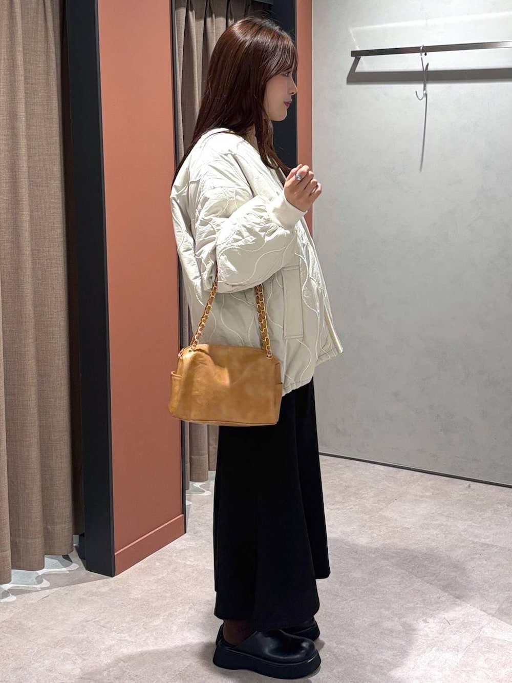 ブラック系のサンダル、ホワイト系のブルゾン、ブラック系のスカートを着用したレディースの冬コーディネートの2枚目の写真