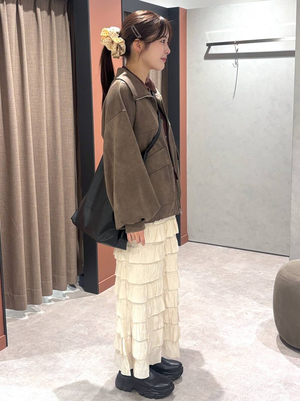 ブラック系のショルダーバッグ、ブラック系のブーツ、ブラウン系のニット/セーターを着用したレディースの秋コーディネートの2枚目の写真