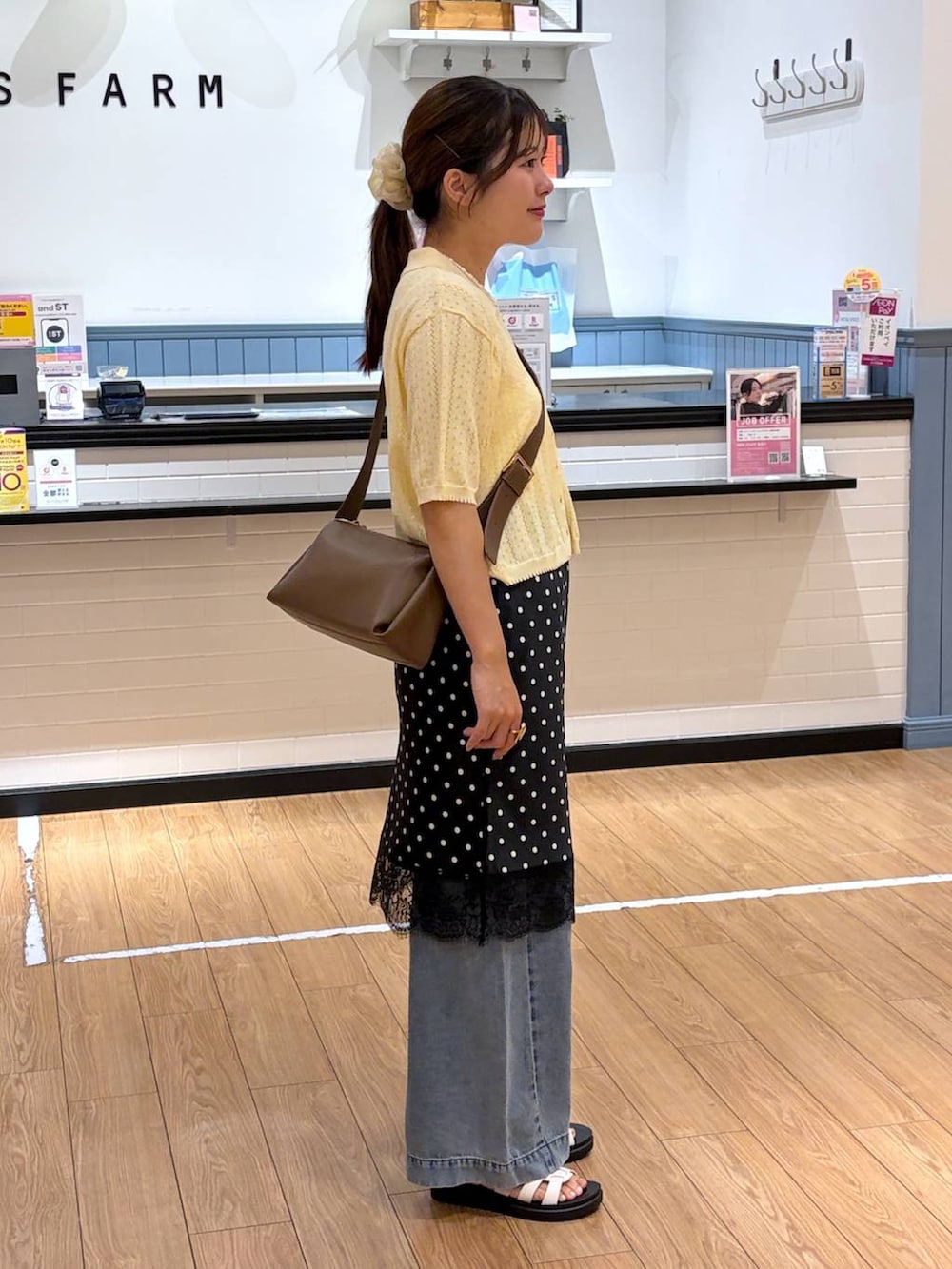 イエロー系のカーディガン/ボレロ、ブラウン系のサンダル、ブラウン系のショルダーバッグを着用したレディースの夏コーディネートの2枚目の写真