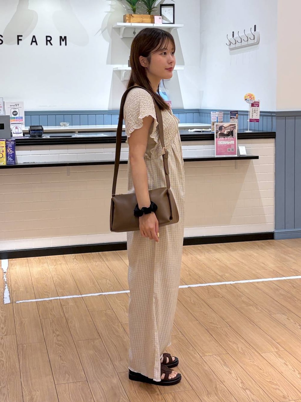 ベージュ系のサロペット/オーバーオール、ブラウン系のサンダル、ブラウン系のショルダーバッグを着用したレディースの夏コーディネートの3枚目の写真