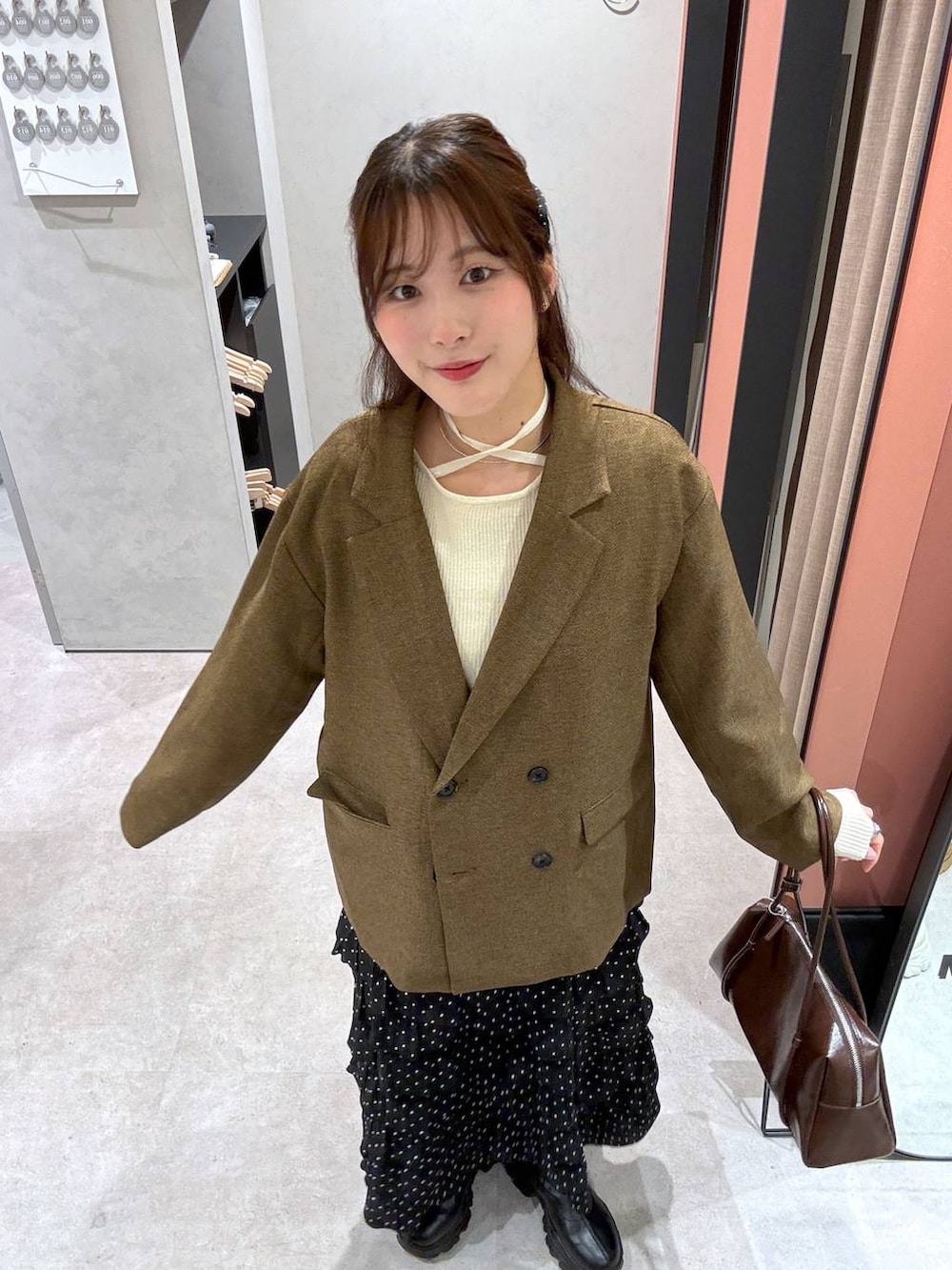ベージュ系のテーラードジャケット、ベージュ系のニット/セーターを着用したレディースの冬コーディネートの3枚目の写真