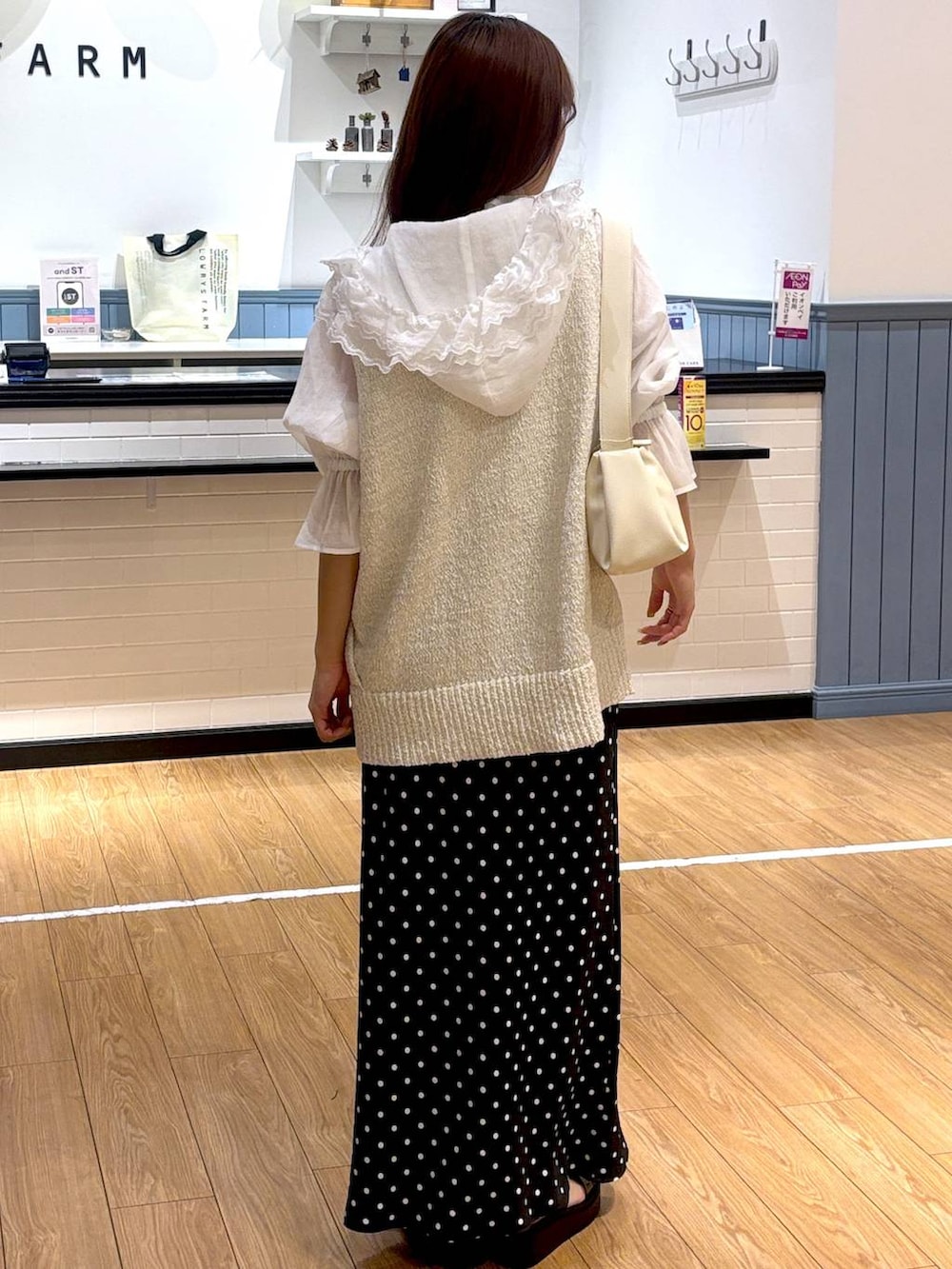 ブラック系のスカート、ホワイト系のシャツ/ブラウス、ブラック系のサンダルを着用したレディースの春コーディネートの3枚目の写真