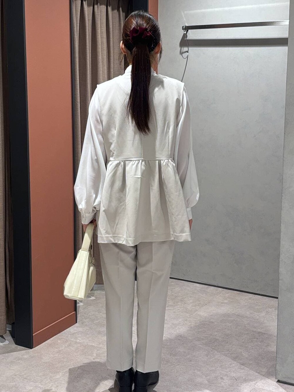 ブラック系のブーツ、ホワイト系のショルダーバッグ、ホワイト系のその他パンツを着用したレディースの冬コーディネートの3枚目の写真