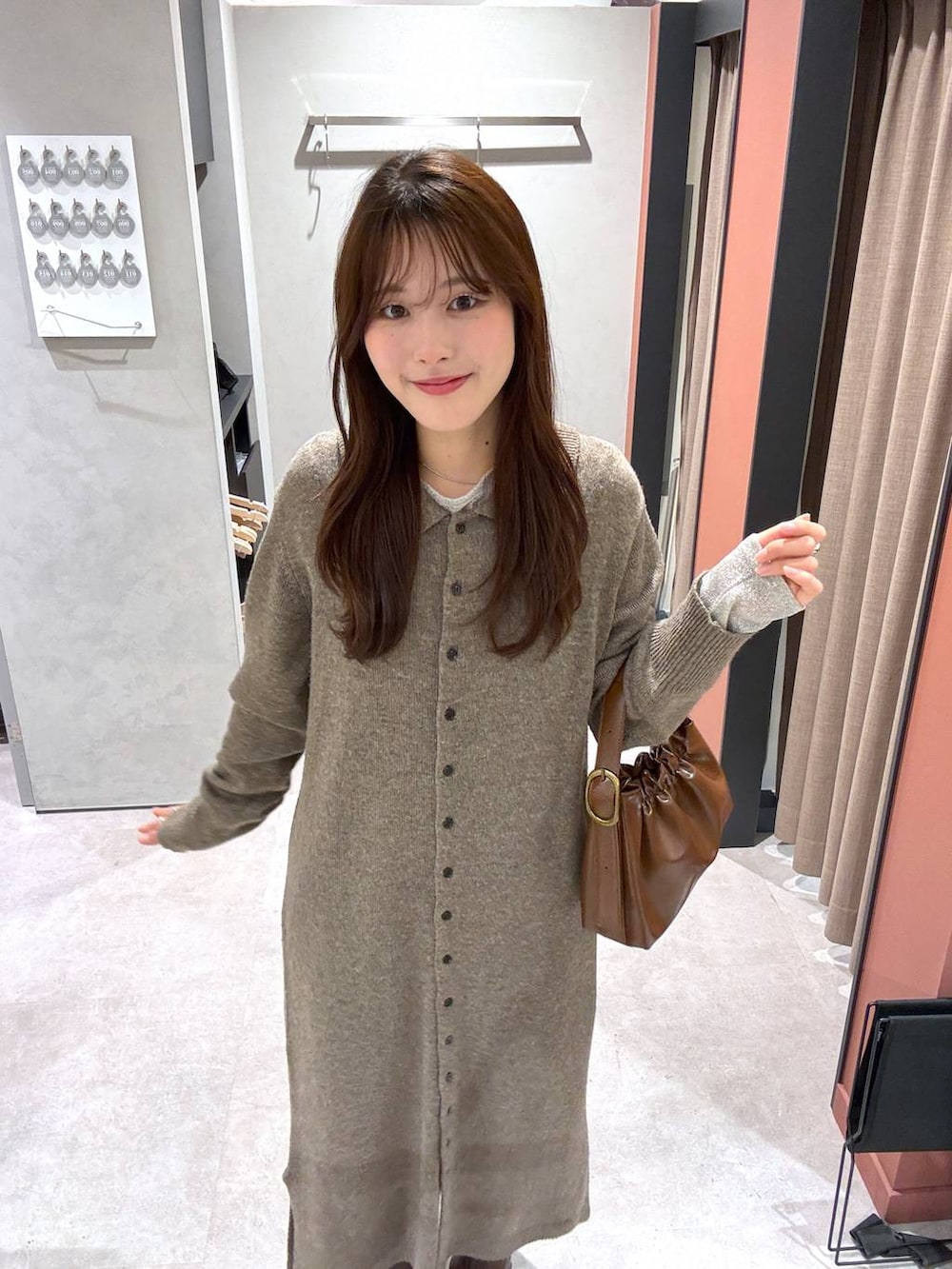 ブラウン系のショルダーバッグ、ブラウン系のワンピース、ホワイト系のTシャツ/カットソーを着用したレディースの冬コーディネートの3枚目の写真