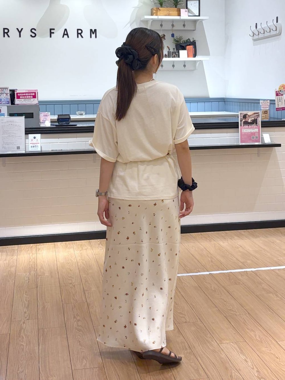ベージュ系のTシャツ/カットソー、ホワイト系のスカート、ブラウン系のサンダルを着用したレディースの夏コーディネートの3枚目の写真
