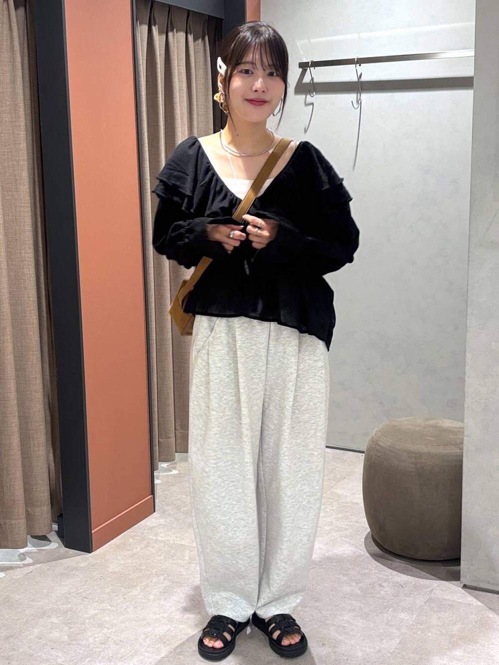 ブラック系のサンダル、グレー系のスウェットパンツ、ブラウン系のショルダーバッグを着用したレディースの夏コーディネートの4枚目の写真