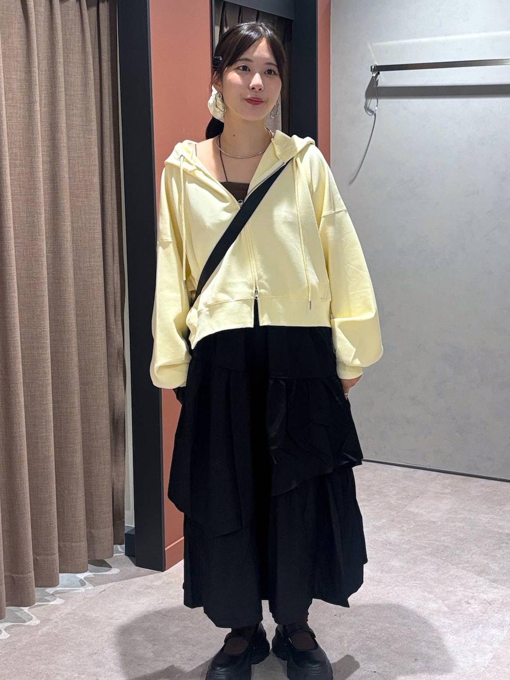 ブラック系のスニーカー、ブラック系のキャミソール、ブラック系のショルダーバッグを着用したレディースの秋コーディネートの4枚目の写真