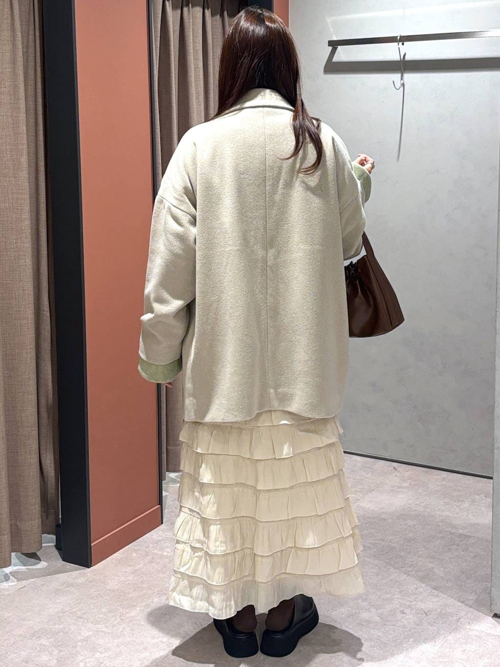 ホワイト系のその他アウター、ホワイト系のスカート、ブラック系のサンダルを着用したレディースの冬コーディネートの3枚目の写真