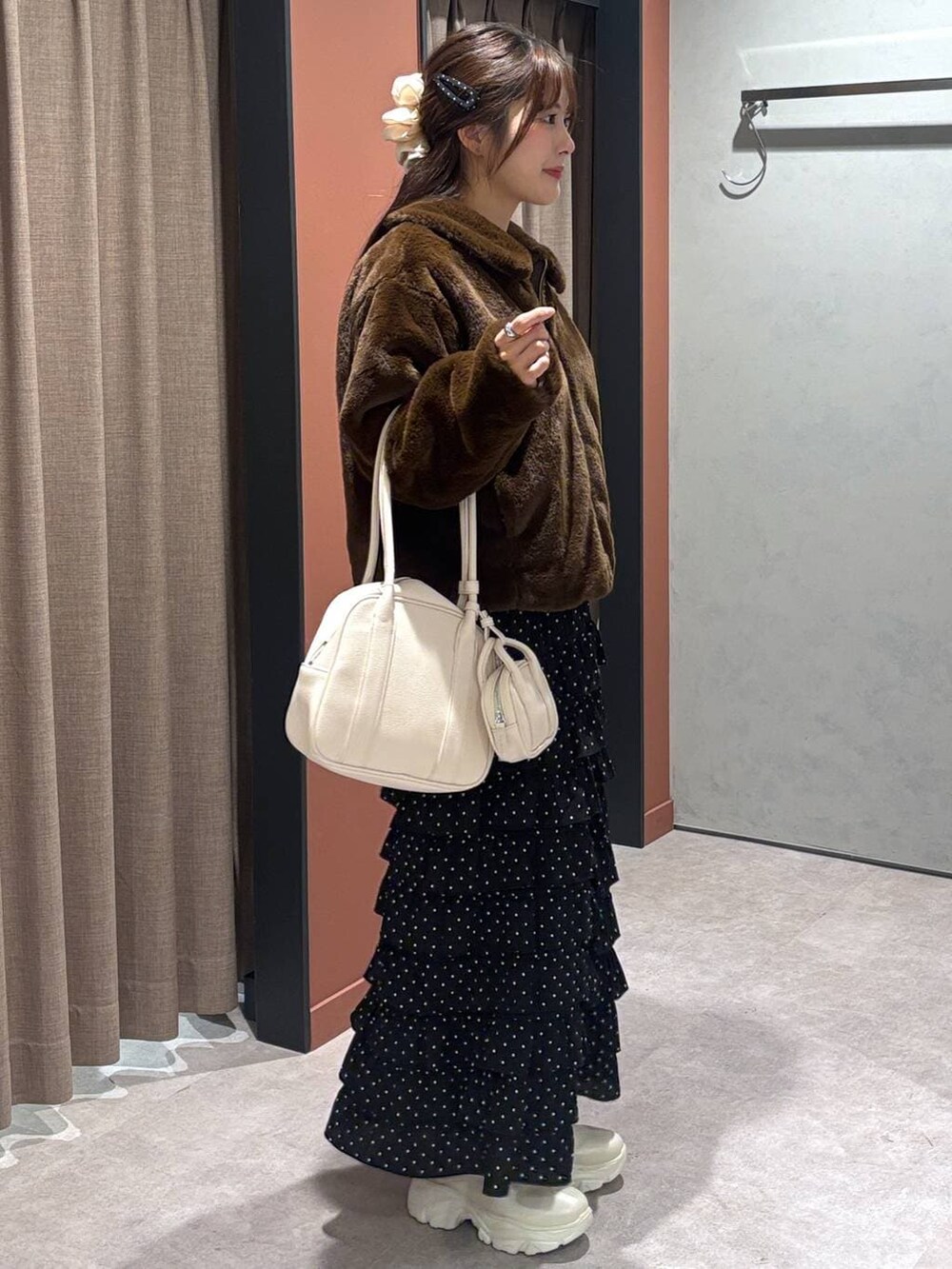 ホワイト系のブーツ、ブラウン系のブルゾン、その他のスカートを着用したレディースの冬コーディネートの2枚目の写真