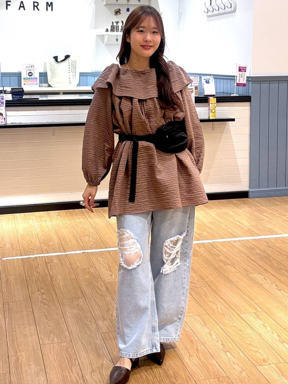 ブルー系のデニムパンツ、ブラック系のボディバッグ/ウエストポーチ、ブラウン系のサンダルを着用したレディースの春コーディネートの3枚目の写真