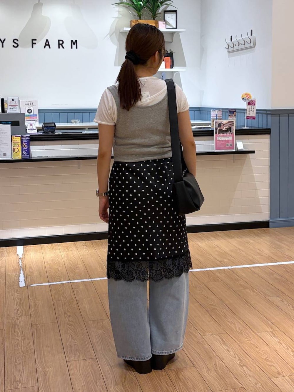ブルー系のデニムパンツ、ブラック系のサンダル、グレー系のタンクトップを着用したレディースの夏コーディネートの3枚目の写真