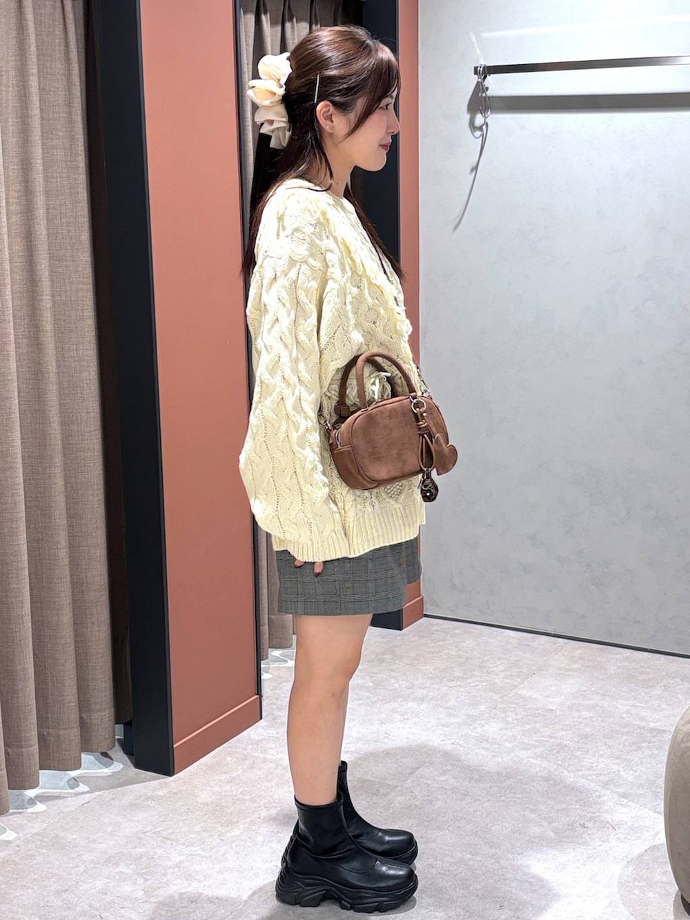 ブラック系のブーツ、グレー系のその他パンツ、ホワイト系のニット/セーターを着用したレディースの秋コーディネートの2枚目の写真