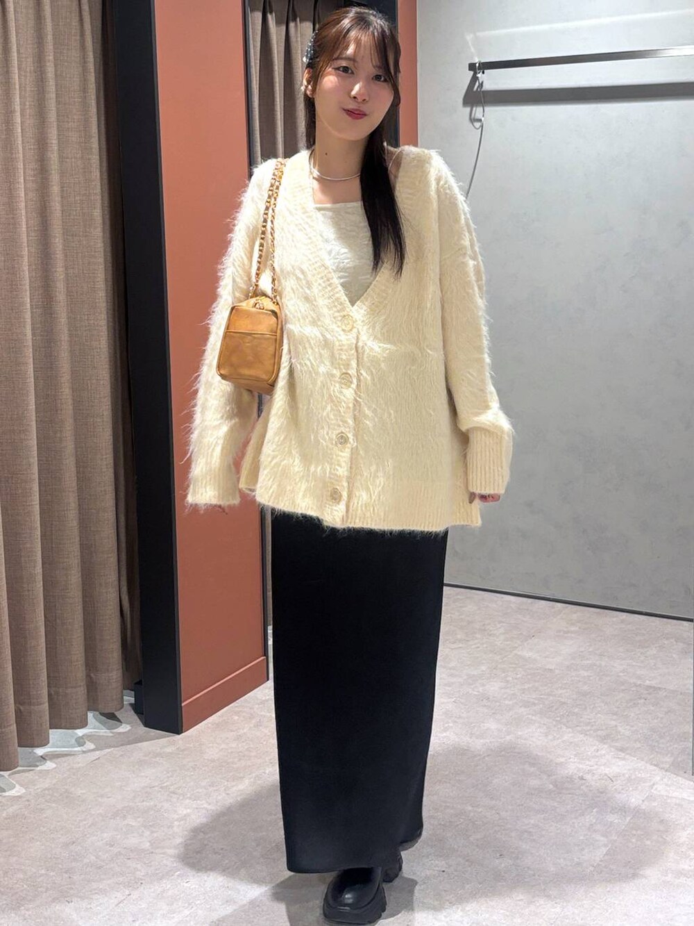 ブラック系のブーツ、ブラック系のスカート、ホワイト系のカーディガン/ボレロを着用したレディースの秋コーディネートの4枚目の写真