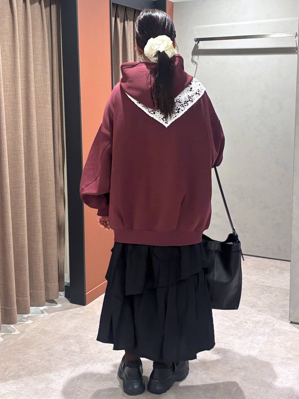 ブラック系のスニーカー、レッド系のパーカー、ブラック系のショルダーバッグを着用したレディースの秋コーディネートの3枚目の写真