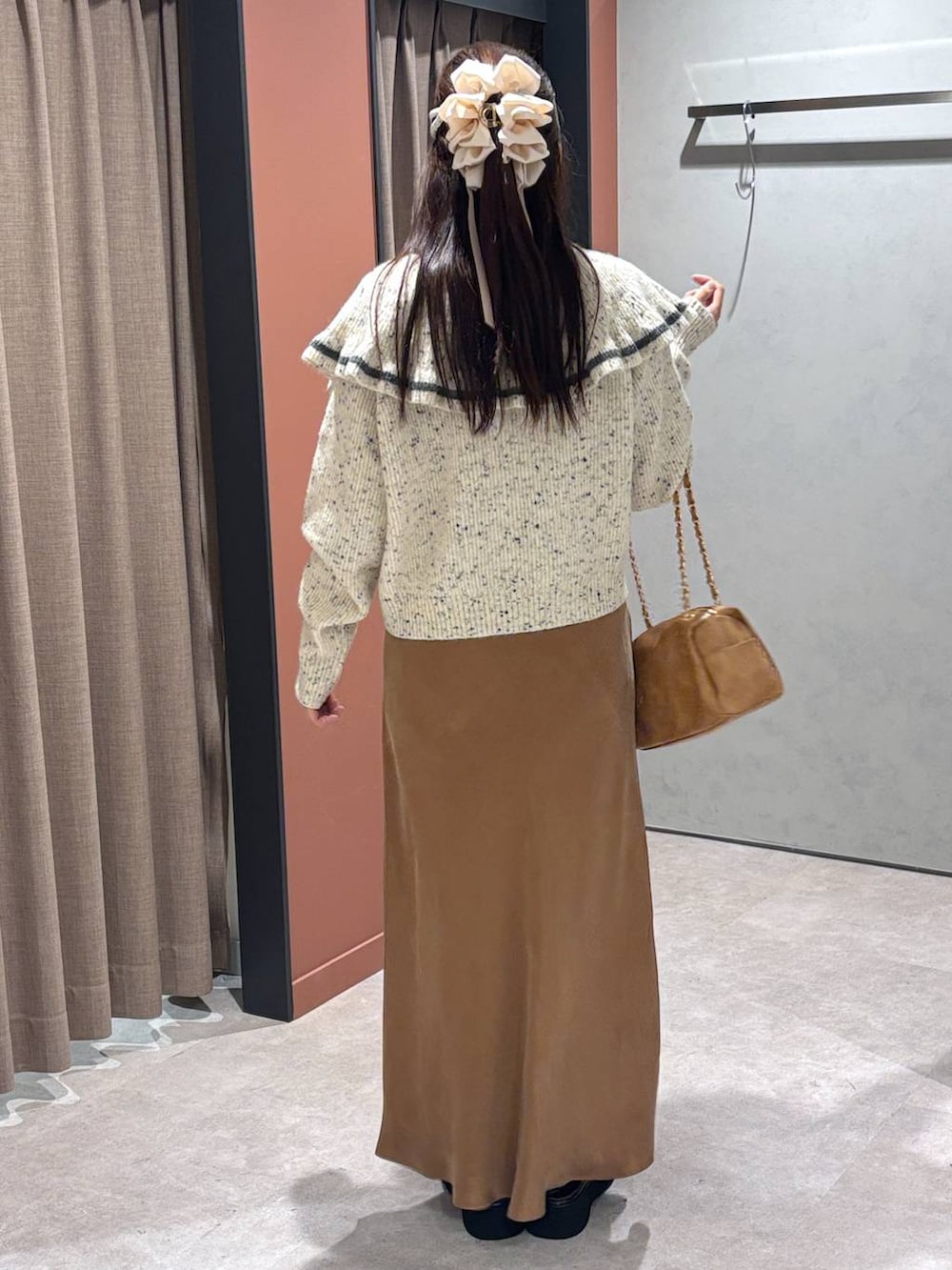 ブラウン系のサンダル、ブラウン系のスカート、ベージュ系のニット/セーターを着用したレディースの秋コーディネートの3枚目の写真