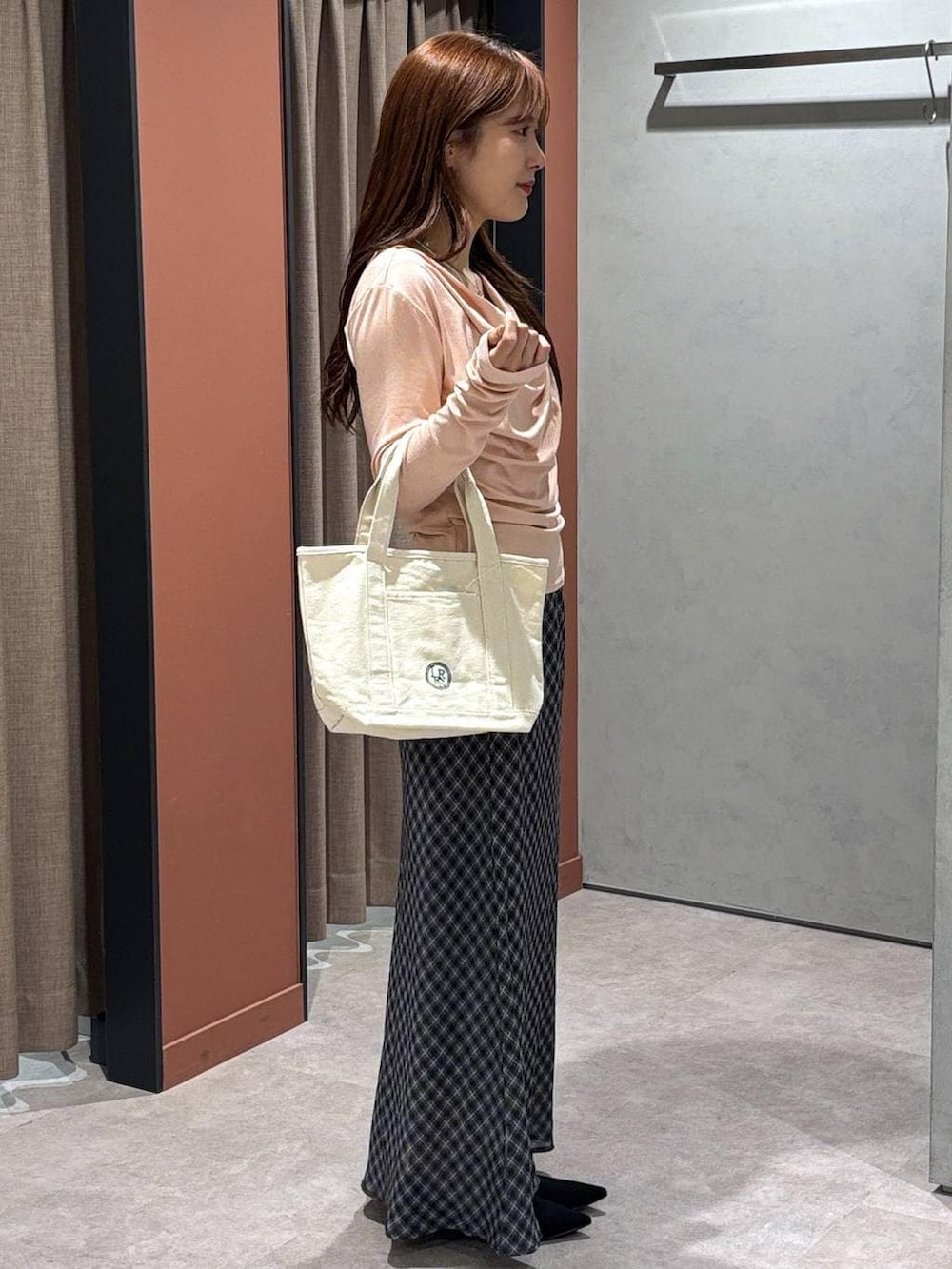 ブラック系のパンプス、ピンク系のTシャツ/カットソー、グレー系のスカートを着用したレディースの春コーディネートの2枚目の写真