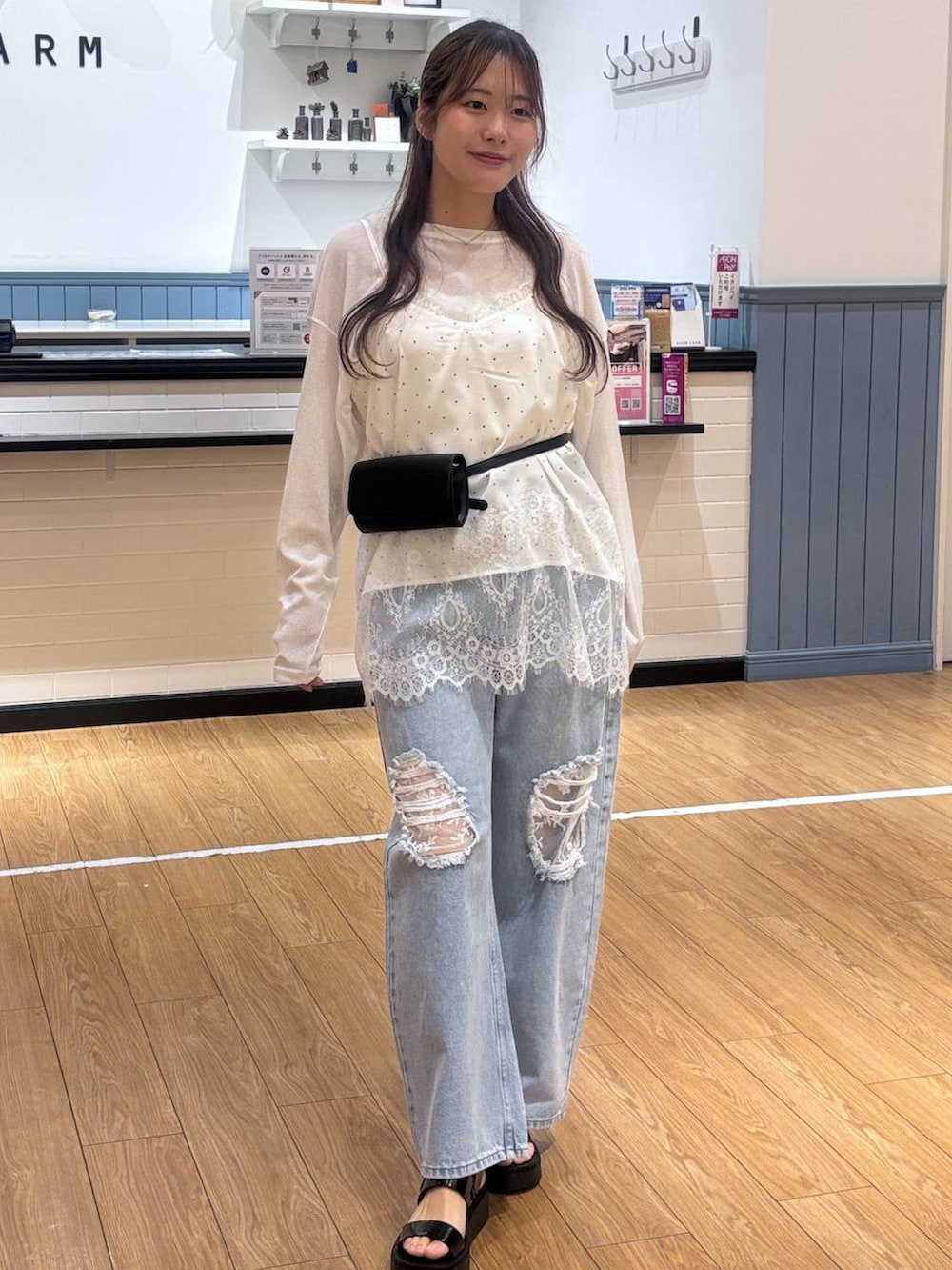 ホワイト系のTシャツ/カットソー、ブルー系のデニムパンツ、ブラック系のサンダルを着用したレディースの春コーディネートの4枚目の写真